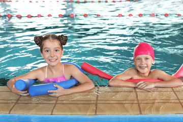 Wall Mural - Little kids with swimming noodles in indoor pool