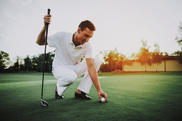 Young Man in White Clothes Playing Golf on Field.