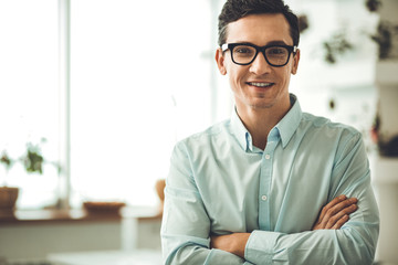 Positive mood. Positive smart man looking at you while being in the office