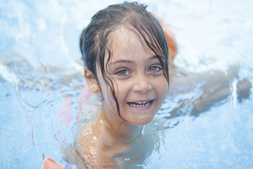 little girl 6 years swimming in the outdoor pool
