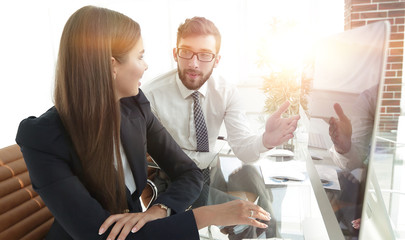 Poster - business woman with a colleague sitting at a Desk