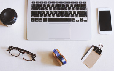 Wall Mural - Flat lay photo of workspace desk with laptop, smartphone, eyeglasses and name card with copy space background