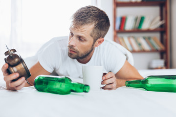 Wall Mural - Young man in bed the morning after night out drinking