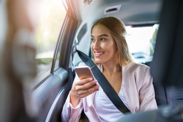 Woman with smart phone in a car
