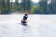 Young athletic woman riding kneeboard on a lake