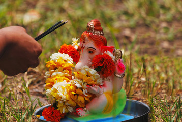 Wall Mural - Ganesha puja before its immersion inside water Pune, India.