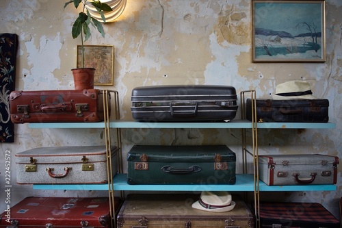 Display Of Old Worn Suitcase Collection On Luggage Rack In