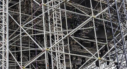  Background of metal construction of a portable concert stage with illuminators.