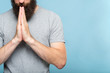 © golubovy - namaste mudra. man holding hands in greeting gesture. yoga practice meditation energy harmony and equilibrium concept. bearded guy on blue background.