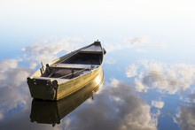 Fishing Boat In A Calm Lake Water/old Wooden Fishing Boat/ Wooden Fishing Boat In A Still Lake Water