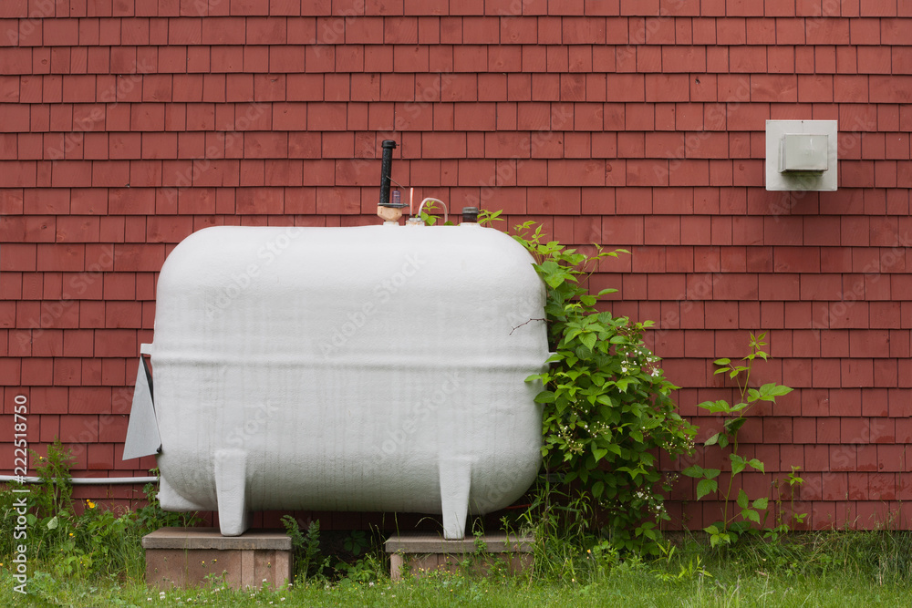 Heating fuel oil tank beside exterior wall.