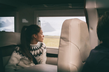 RV camper van travel Asian girl sitting in back of motorhome car on Iceland road trip. Europe vacation lifestyle.