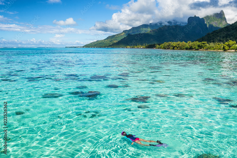 Luxury travel vacation tourist woman snorkeling in Tahiti ocean, Moorea island, French Polynesia. Snorkel swim girl swimming in crystalline waters and coral reefs. - obrazy, fototapety, plakaty 