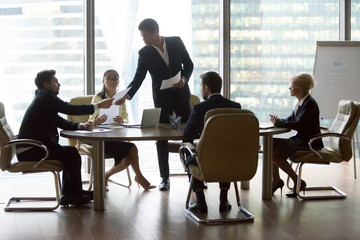 Poster - Businesspeople colleagues and black team leader discussing and reviewing report in meeting at conference room. Multiracial group professional share information and reach agreement and signing contract