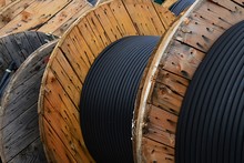 Detail Of Thick Isolated Electric Cables Coiled On Wooden Cable Reels In Storage