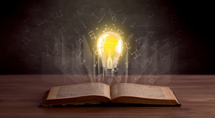 Wall Mural - Shiny alphabet letters and yellow lightbulb hovering over open book 