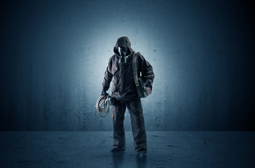 Wall Mural - Bad agent in a dark room with arms on his hand and gas mask
