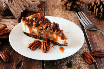 Poster - Slice of pecan caramel cheesecake. Table scene with a rustic wood background. Autumn dessert.