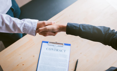 Wall Mural - Dealer partnerships people shaking hands with making a contract in the office.