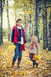 © sborisov - Smiling little girl and her mother enjoy walk in autumn park and play with bright autumn leaves