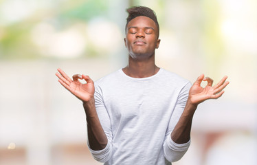 Canvas Print - Young african american man over isolated background relax and smiling with eyes closed doing meditation gesture with fingers. Yoga concept.