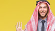 Young handsome arabian man with long hair wearing keffiyeh over isolated background showing and pointing up with fingers number six while smiling confident and happy.