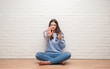 © Krakenimages.com - Young brunette woman sitting on the floor drinking glass of water with open hand doing stop sign with serious and confident expression, defense gesture
