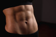 Close up of fit female abs isolated on black background with copy space. Fitness female and trained stomach, Perfect Slim Body. Sport, Bodybuilding, Fitness Concept