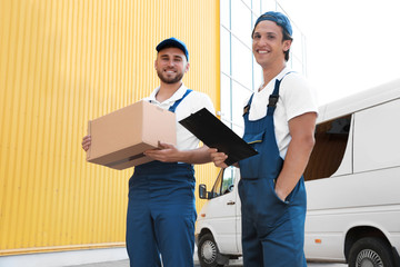 Wall Mural - Male movers with box and clipboard near van outdoors