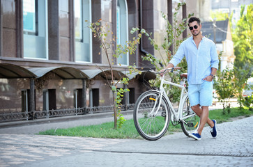 Wall Mural - Handsome young hipster man with bicycle outdoors