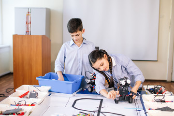 Wall Mural - Cheerful smart kids working on the tech project at school