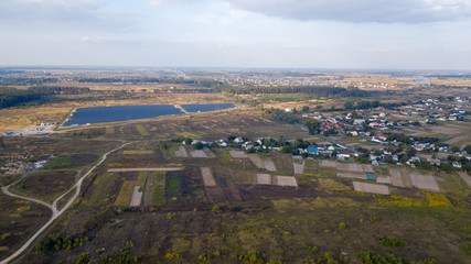 Wall Mural - aerial view agriculture field and mountains. Summer day landscape. Flying over the beautiful rural landscape. Aerial camera shot.