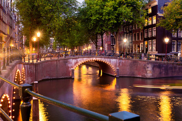 Fototapete - Amsterdam evening with bridges, canals and lights at sunset