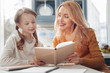© zinkevych - Keep smiling. Cheerful female person expressing positivity while doing homework with her daughter