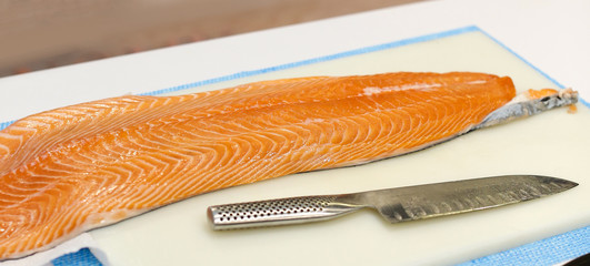 Chef cutting fresh salmon fillet in kitchen, chef cuts the salmon .Chef cutting fresh salmon fillet in kitchen, chef cuts the salmon .