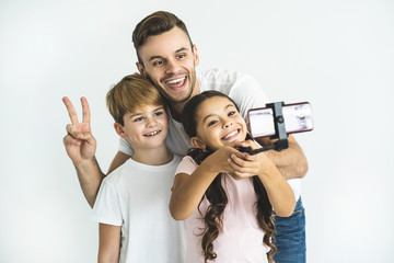 Wall Mural - The happy father and children take selfie on the white background