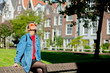 © Masson - Young girl in jeans jacket and backpack sitting at street in Amsterdam. Holland, Netherlands. Autumn season
