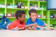 © weedezign - Two boy kid lay down on floor and reading tale book  in preschool library,Kindergarten school education concept.