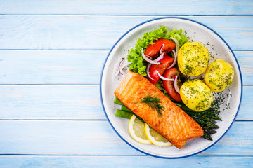 Grilled salmon with boiled potatoes, asparagus and vegetable salad