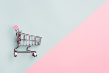 close up of supermarket grocery push cart for shopping with black wheels on white background. concep