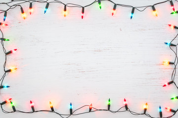 christmas lights bulb frame decoration on white wood. merry christmas and new year holiday backgroun