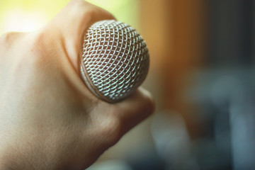 Closeup hand holding the microphone musical concept.Recording Studio Room concept.