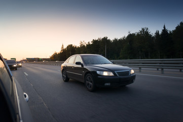 Highway transportation with cars during the sunset