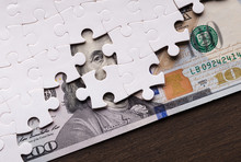 American Dollar Hidden Under Puzzle Pieces