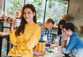 Portrait Asian business woman over group of young creative team working in cafe