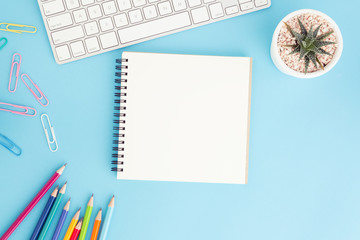 Wall Mural - blank notebook with keyboard and pencil on blue background,flat lay photo of notebook for your messa