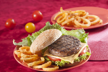 Beef Burger with bell pepper and lettuce with cherry red and yellow tomato on Red background 