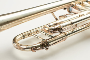 Close up rusty trumpet on white background. Detail of old vintage trumpet instrument. Antique equipment of orchestra.