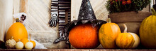 Halloween Decorated Front Door With Various Size And Shape Pumpkins And Skeletons. Halloween House Exterior Spooky Decorations Banner.