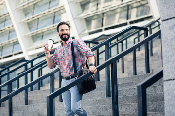 Wall Mural - Cheerful handsome man drinking tasty coffee outdoors